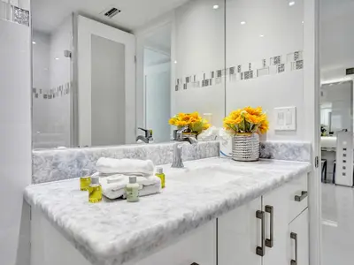 a white bathroom with a sink and a mirror at Beachfront Condo w Beach Service 1207 in Miami Beach