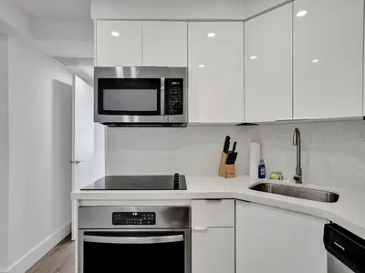 a kitchen with white cabinets and a stove top oven at Gorgeous Miami Beach Condo 1614 in Miami Beach