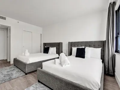 two beds in a bedroom with white sheets and pillows at Gorgeous Miami Beach Condo 1614 in Miami Beach