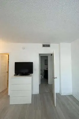 a living room with a flat screen tv on a dresser at Apt w/2 Queen Beds & Ocean View at Tides in Hollywood