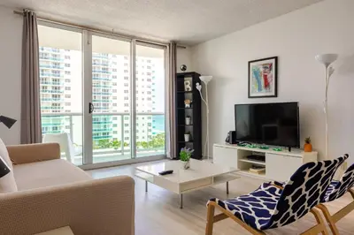 a living room with a couch and a tv at Apt w/2 Queen Beds & Ocean View at Tides in Hollywood