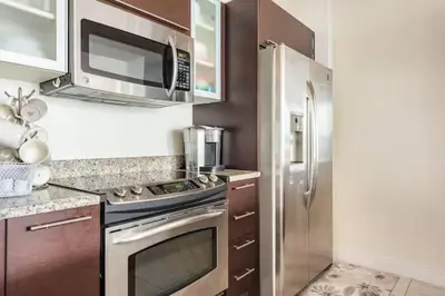 a kitchen with a stainless steel refrigerator and microwave at Brickell High Rise Living at its best! w/ Pool Gym in Miami