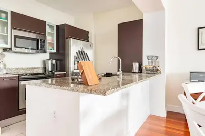 a kitchen with a granite counter top and appliances at Brickell High Rise Living at its best! w/ Pool Gym in Miami