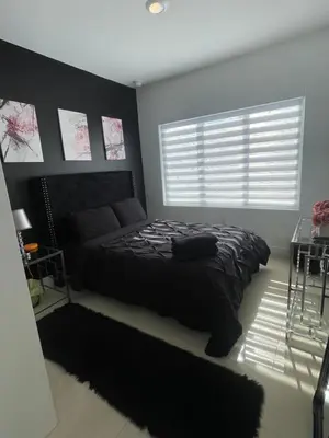 a bedroom with a black bed and a window at NEW 3 Story in Homestead- 3/2.5 Balcony & Rooftop in Homestead