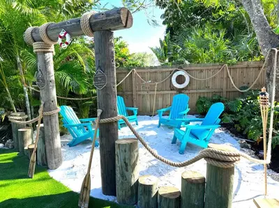 a yard with blue chairs and a swing at Villa Santa Maria in Cutler Bay