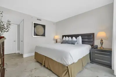 a white bedroom with a large bed and two lamps at Modern Bay View Balcony In The Grove Free Parking in Miami