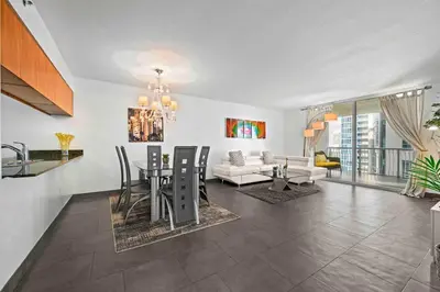 a kitchen and living room with a table and chairs at Luxury 1 BDR • 30th Floor • Brickell • Water Views in Miami