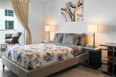 a bedroom with a bed and two lamps and a balcony at Luxury 1 BDR • 30th Floor • Brickell • Water Views in Miami