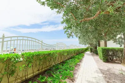 a walkway next to a hedge with a bridge in the background at Apt w/2 Queen Beds & Canal View at Tides in Hollywood