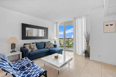 a living room with a blue couch and a table at Apt w/2 Queen Beds & Canal View at Tides in Hollywood