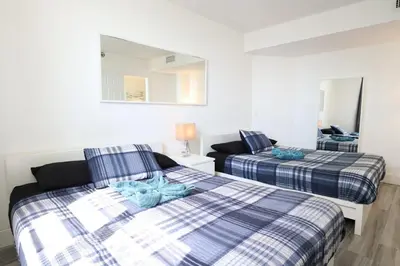 a bedroom with two beds and a mirror at 2Bed/2Bath, 4QueenBeds & OceanView at Tides in Hollywood