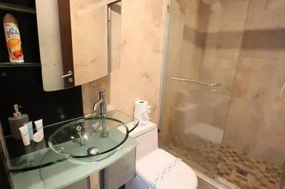 a bathroom with a glass sink and a toilet at 2Bed/2Bath, 4QueenBeds & OceanView at Tides in Hollywood