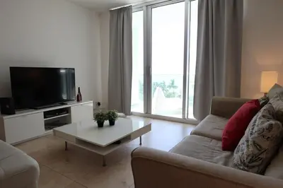 a living room with a couch and a tv and a table at 2Bed/2Bath, 4QueenBeds & OceanView at Tides in Hollywood