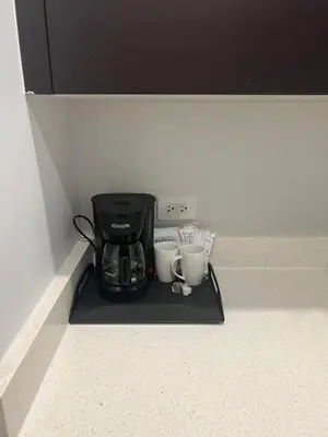 a coffee maker and two cups on a black tray at Doral Pool 1107 by Wave Properties in Miami