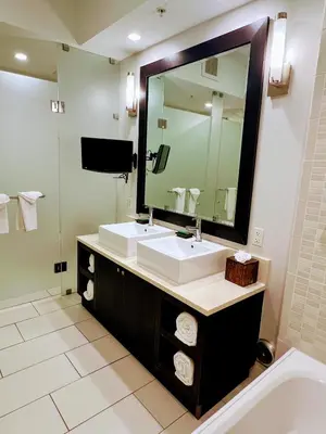a bathroom with a sink and a large mirror at Doral Pool 1107 by Wave Properties in Miami