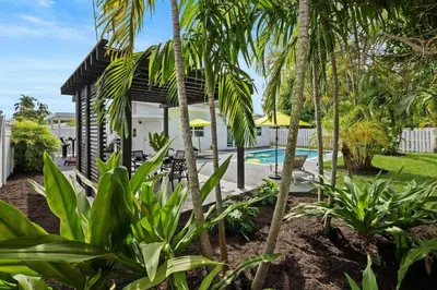 a villa with a swimming pool and palm trees at Casa Mojito in Fort Lauderdale