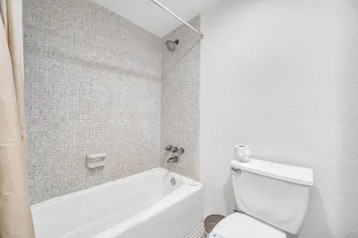 a bathroom with a white tub and a toilet at Spacious 1 BDR 1.5 BTH • Hallandale Beach in Hollywood