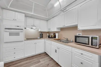 a white kitchen with white cabinets and a microwave at Spacious 1 BDR 1.5 BTH • Hallandale Beach in Hollywood