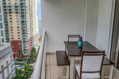 a table and chairs on a balcony with a view of a city at Beautiful 1 BED 1 BTH • Brickell in Miami