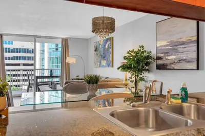 a kitchen with a sink and a living room at Beautiful 1 BED 1 BTH • Brickell in Miami