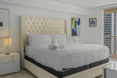 a white bedroom with a large bed and a window at Exquisite 1 Bed • 33 Floor •Brickell • Ocean Views in Miami