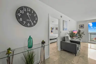 a living room with a large clock on the wall at Exquisite 1 Bed • 33 Floor •Brickell • Ocean Views in Miami