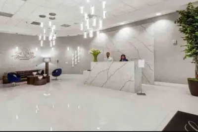 two people standing at a counter in a lobby at Exquisite 1 Bed • 33 Floor •Brickell • Ocean Views in Miami
