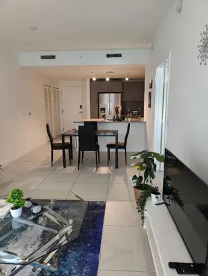 a kitchen and living room with a table and chairs at Stylish 1-Bedroom Getaway Apt- pool & gym in Miami