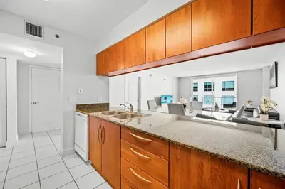 a kitchen with wooden cabinets and a counter top at Splendid 1 Bed Apartment • Brickell • Water Views in Miami