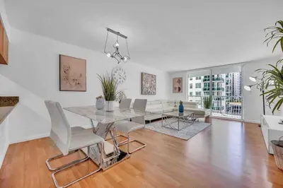 a dining room and living room with a table and chairs at LUX 1 BDR 1 BTH • Brickell • Pool & Ocean Views in Miami