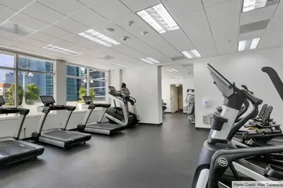 a gym with cardio equipment and a woman on a treadmill at LUX 1 BDR 1 BTH • Brickell • Pool & Ocean Views in Miami