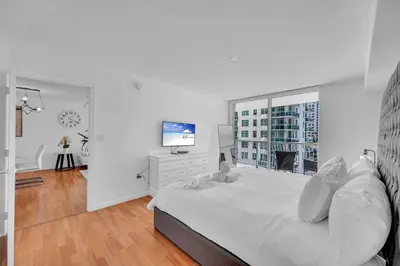 a white bedroom with a large bed and a window at LUX 1 BDR 1 BTH • Brickell • Pool & Ocean Views in Miami