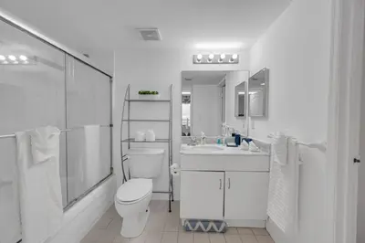 a white bathroom with a toilet and a sink at Ocean view 1BR Condo Brickell-FreeParking in Miami