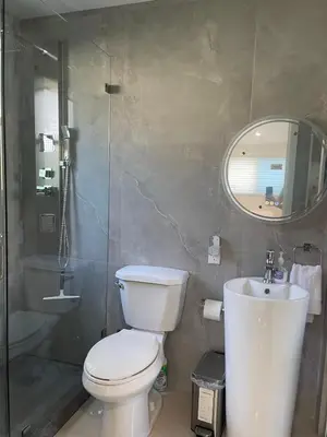a bathroom with a toilet and a sink and a mirror at Studio close to airport in Dania Beach