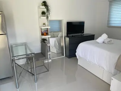 a bedroom with a bed and a flat screen tv at Studio close to airport in Dania Beach