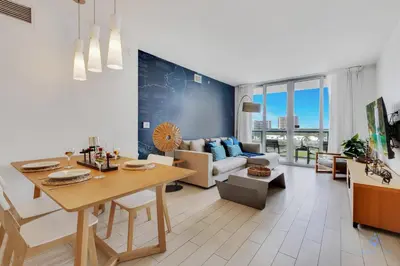 a living room with a table and a couch at Beachwalk Resort infinity Pool Balcony Views in Hallandale Beach