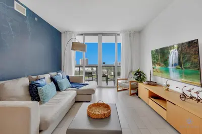 a living room with a couch and a tv at Beachwalk Resort infinity Pool Balcony Views in Hallandale Beach