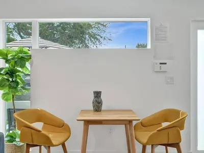 two chairs and a table in a room with a window at Contemporary 2BR Home with Pool & BBQ Access in Fort Lauderdale