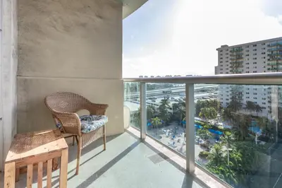 a balcony with a chair and a view of a resort at Sunny Isles Ocean Reserve Condo Apartments in Miami Beach