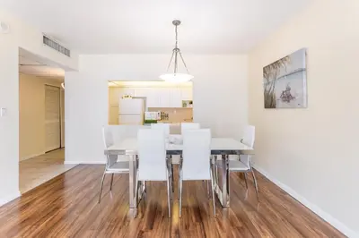 a dining room with white walls and a table and chairs at Sunny Isles Ocean Reserve Condo Apartments in Miami Beach