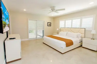 a bedroom with a bed and a flat screen tv at Amazing Villa WALK 5 minutes to Hollywood Beach in Hollywood
