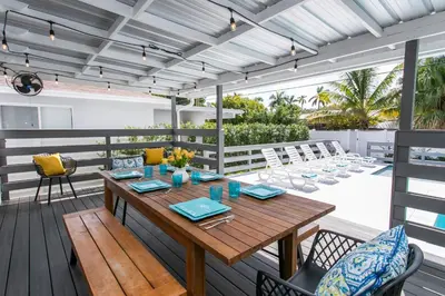 a patio with a wooden table and chairs at Luxury Villa 5BR and 3BR in Hollywood Lakes near Beach in Hollywood