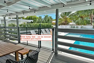 a deck with a table and chairs and a swimming pool at Luxury Villa 5BR and 3BR in Hollywood Lakes near Beach in Hollywood