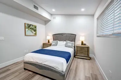 a bedroom with a large bed and two night stands at Walk to Beach Luxury 4BR & 4BA Villa Hollywood Lakes in Hollywood