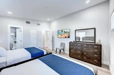 a bedroom with two beds and a dresser and a mirror at Walk to Beach Luxury 4BR & 4BA Villa Hollywood Lakes in Hollywood
