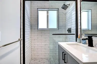 a white bathroom with a sink and a shower at Walk to Beach Luxury 4BR & 4BA Villa Hollywood Lakes in Hollywood