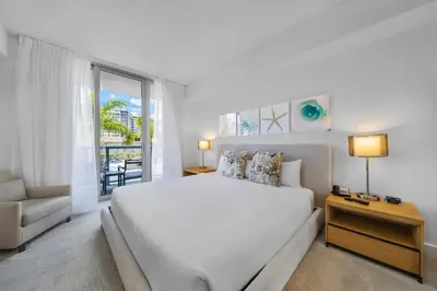a white bedroom with a bed and a couch at Beachwalk 2 Bedrooms with Kitchen 2 Bathroom & Gym in Hallandale Beach