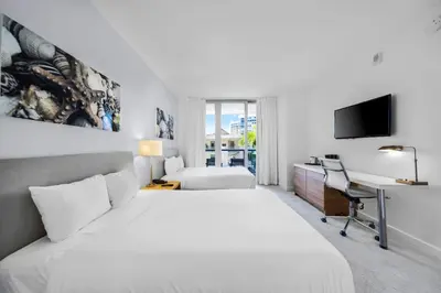 a hotel room with a large bed and a desk at Beachwalk 2 Bedrooms with Kitchen 2 Bathroom & Gym in Hallandale Beach