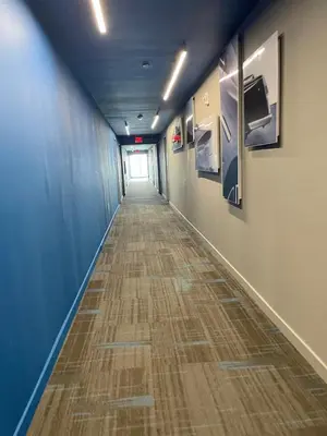 a long hallway with blue walls and a wooden floor at Beachwalk 2 Bedrooms with Kitchen 2 Bathroom & Gym in Hallandale Beach