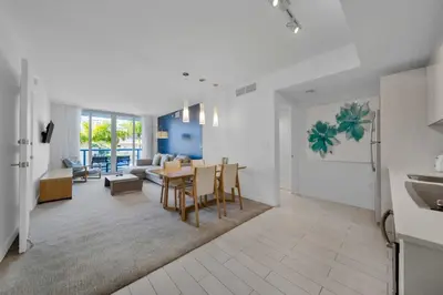 a kitchen and living room with a table and chairs at Beachwalk -1 Bedroom With Kitchen Pool And Gym in Hallandale Beach